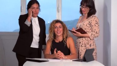 Modern ofiste genç girişimcilerin oturumları var. Latin ve Kafkasyalı, genç esmerler ve iş yerinde genç bir sarışın. Toplantıda başka bir ofisteki video görüşmesiyle gülümsüyor.