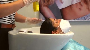Kuaför ve müşteri maske takıyor. Covid-19 salgınında kuaförlerin güvenlik önlemleriyle yeniden açılacak. Yeni normal, koronavirüs, sosyal uzaklık