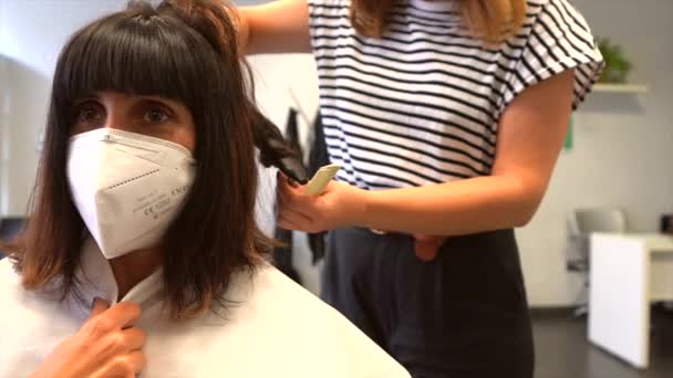 マスクとクライアントと美容師波状の髪型を終了します Covid 19パンデミックにおける美容師の安全対策 新しい正常 コロナウイルス 社会的距離 — ストック動画