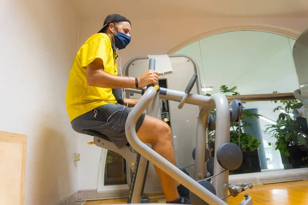 Hombre Joven Caucásico Con Mascarilla Facial Una Máquina Gimnasio Realizando —  Fotos de Stock