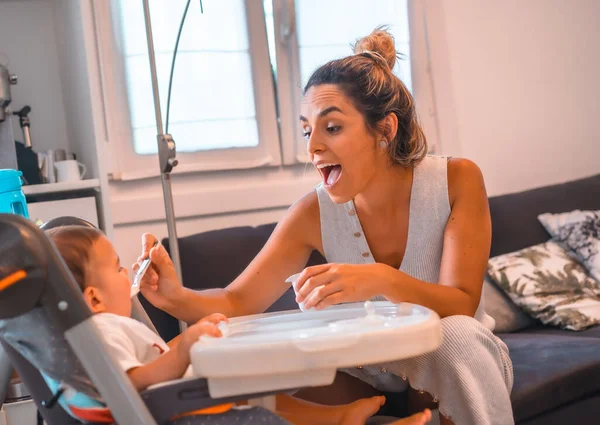 Jovem Mãe Caucasiana Alimentando Seu Filho Iogurte Enquanto Senta Cadeira — Fotografia de Stock