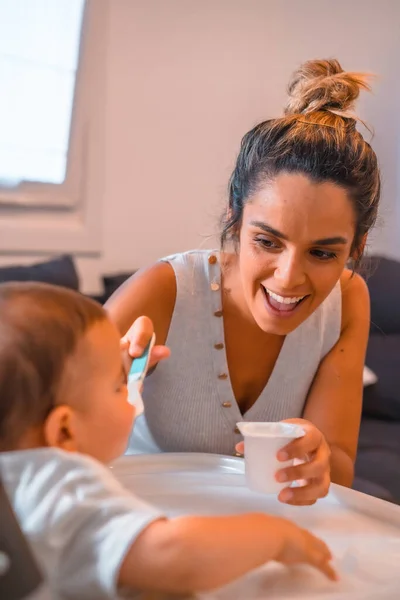 Jovem Mãe Caucasiana Alimentando Seu Filho Iogurte Enquanto Senta Cadeira — Fotografia de Stock