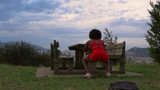 Выполнение Силовых Упражнений Прыжки Один Стол Парке Девушка Красных Нарядах — стоковое видео