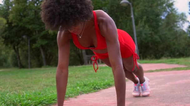 公园里的力量训练 两个穿红色和浅蓝色衣服的多族裔健身女孩 金发白人女孩和深色皮肤拉丁女孩 — 图库视频影像
