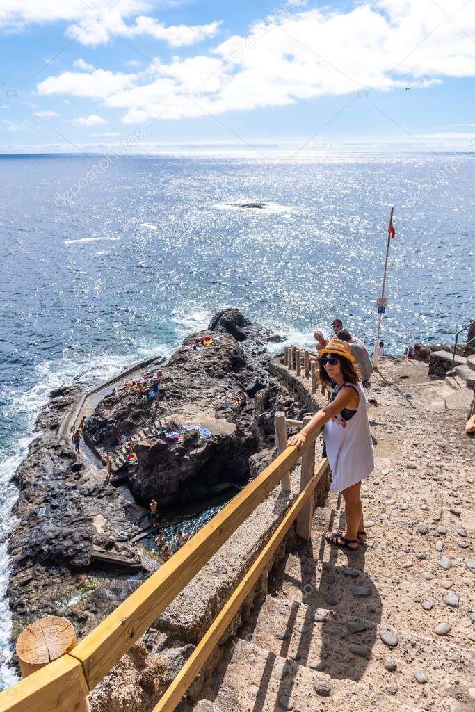 A young tourist in summer from the viewpoint looking and enjoying the cove of Puerto de Puntagorda, island of La Palma, Canary Islands. Spain