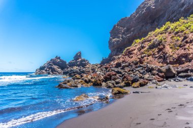 La Plama, Kanarya Adaları 'nın doğusundaki Playa de Nogales kayalıklarında yazın keyfini çıkaran genç bir turist. İspanya