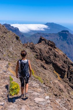 Caldera de Taburiente, La Palma, Kanarya Adaları 'nın tepesinde Roque de los Muchachos yolunda yürüyen genç bir kadın. İspanya