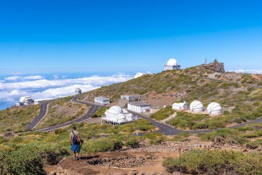 Caldera de Taburiente, La Palma, Kanarya Adaları 'ndaki Roque de los Muchachos Ulusal Parkı' nın teleskoplarına bakan genç bir adam. İspanya