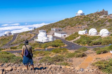 Caldera de Taburiente, La Palma, Kanarya Adaları 'ndaki Roque de los Muchachos Ulusal Parkı' nın teleskoplarına bakan genç bir adam. İspanya