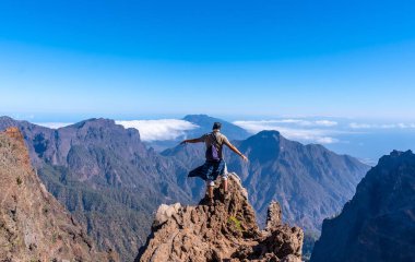 Genç bir adam, Roque de los Muchachos yakınlarındaki Caldera de Taburiente yanardağının tepesindeki yürüyüşü bitirdikten sonra bir yaz öğleden sonra, La Palma, Kanarya Adaları 'nda. İspanya