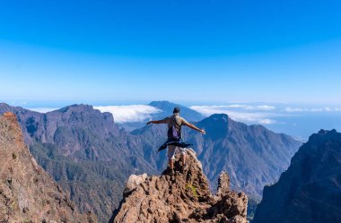 Genç bir adam, Roque de los Muchachos yakınlarındaki Caldera de Taburiente yanardağının tepesindeki yürüyüşü bitirdikten sonra bir yaz öğleden sonra, La Palma, Kanarya Adaları 'nda. İspanya