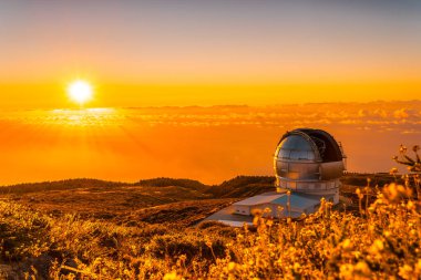 Large Canary Telescope called Grantecan optico del Roque de los Muchachos in the Caldera de Taburiente in a beautiful orange sunset, La Palma, Canary Islands. Spain clipart