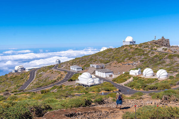 A young man on the trail looking at the telescopes of the Roque de los Muchachos national park on top of the Caldera de Taburiente, La Palma, Canary Islands. Spain
