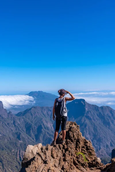 Bir yaz öğleden sonra La Palma, Kanarya Adaları 'nda Roque de los Muchachos yakınlarındaki Caldera de Taburiente volkanının tepesinden dışarı bakan genç bir kadın. İspanya