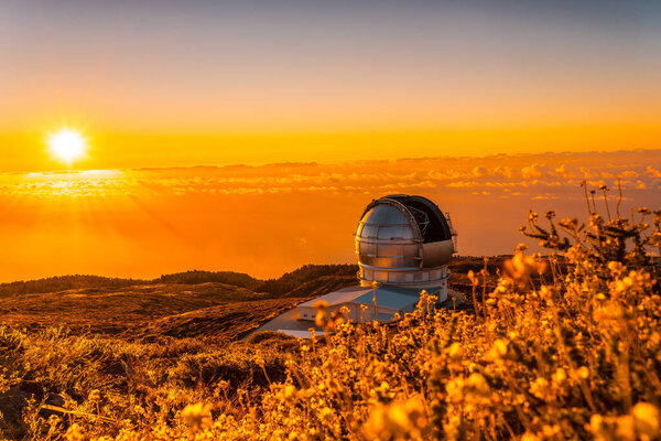 Large Canary Telescope called Grantecan optico del Roque de los Muchachos in the Caldera de Taburiente in a beautiful orange sunset, La Palma, Canary Islands. Spain