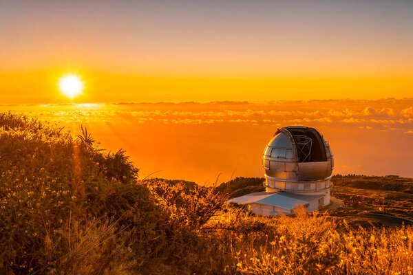Large Canary Telescope called Grantecan optico del Roque de los Muchachos in the Caldera de Taburiente in a beautiful orange sunset, La Palma, Canary Islands. Spain