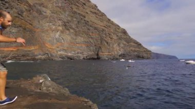 Kanarya Adaları 'ndaki La Palma adasındaki Puerto de Puntagorda koyunda yavaş çekimde suya atlayan genç bir adam. İspanya