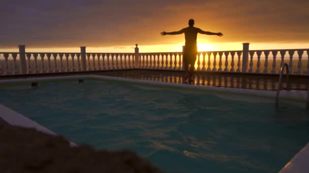 Молодой Человек Прыгает Воду Бассейна Отеля Красивом Закате Острове Пальма — стоковое видео