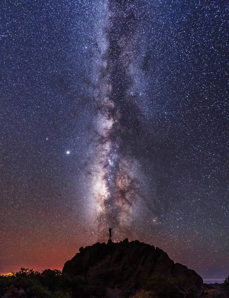 Silhouette of a young man under the stars looking at the lactea way of the Caldera de Taburiente near the Roque de los Muchahos on the island of La Palma, Canary Islands. Spain, astrophotography