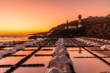Günbatımı tuzlu düzlüklerde ve arka planda Fuencaliente Deniz feneri volkanların rotası üzerinde La Palma, Kanarya Adaları, İspanya