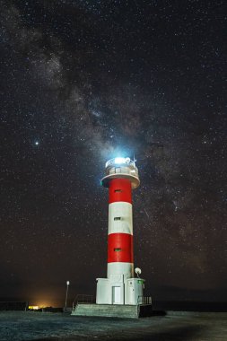 Fuencaliente lighthouse with the Milky Way diagonally at night on the route of the volcanoes south of the island of La Palma, Canary Islands, Spain clipart