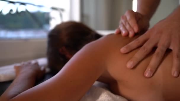 一名年轻女子躺在担架上的理疗师的推拿细节 骨质疏松症 放松推拿 后面的运动视频治疗 — 图库视频影像
