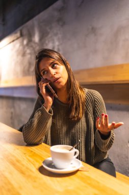 Kafkasyalı genç bir esmer girişimci bir kafede çalışıyor. Telefonda konuşmak ve kahve içmek.