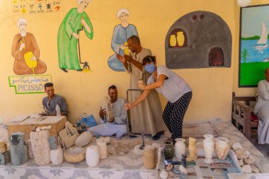 Luxor, Mısır; 11 Ekim 2020: Genç bir turist, Luxor 'daki kaymak gibi heykellerle gülüyor ve çalışıyor