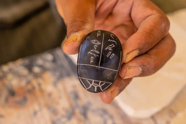 Writing in Egyptian hieroglyphic writing on a black alabaster scarab at Luxor. Egypt