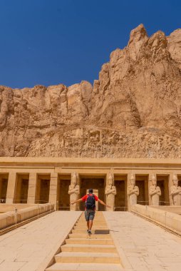 Genç bir adam Luxor 'daki Hatshepsut Cenaze Tapınağı' na merdivenlerden çıkıyor. Mısır
