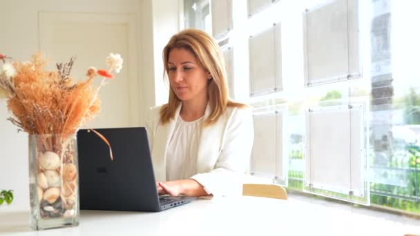 Kvindelig Administrator Taler Til Telefonen Mens Bruger Laptop Arbejder Kontoret – Stock-video