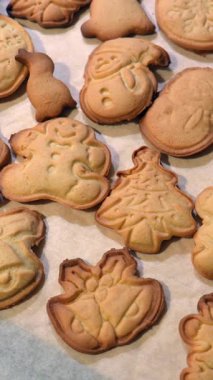 Noel kurabiyeleri ve şenlikli şekiller kağıt üzerinde soğuyor, sıcak ve davetkar bir tatil atmosferi yaratıyor.