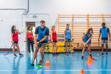 Fotokopi oyuncuları sahada antrenman yaparken antrenman yapıyor, antrenman yaparken sopa tutma becerilerine ve takım çalışmasına odaklanıyor.