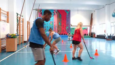 Genç sporcular, spor salonunda dinamik bir şekilde hareket ederek yoğun antrenman sırasında takım çalışması ve atletik koordinasyon gösteriyorlar.