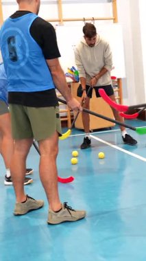 Profesyonel hokey oyuncuları spor salonunda birlikte antrenman yapıyor, yapılandırılmış tatbikatlar yoluyla becerilerini geliştiriyor ve yoğun antrenmanlar sırasında takım koordinasyonunu geliştiriyor.
