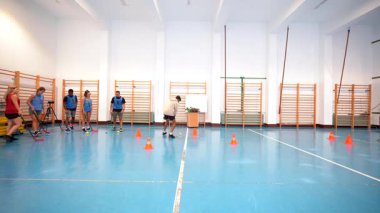 Sporcular spor salonunda koniler arasında hareket etme, antrenman sırasında bireysel beceri geliştirme ve takım koordinasyonu sergileme teknikleri üzerinde çalışıyorlar.
