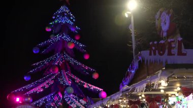 Süngü, Fransa 'da gece karanlığında renkli Noel ağacı ışıkları renk değiştirip neşeli ve büyülü bir atmosfer yaratıyor.