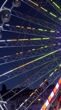 Süngü, Fransa 'da gece gökyüzüne doğru dönen dönme dolabı aydınlatan renkli ışıklar neşeli bir atmosfer yaratıyor.