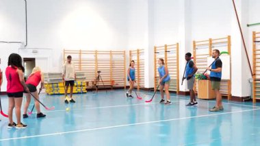 Jimnastik hokeyi oyuncuları geçiş ve yapışkan tutuş talimleri yapıyor, takım çalışmalarını ve bireysel becerilerini dinamik bir eğitim oturumunda geliştiriyorlar.