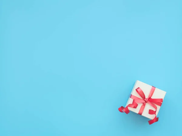 白色礼品盒 蓝色背景上有红丝带 母亲节 情人节 圣诞节的概念 问候卡或邀请卡 具有复制空间的平面布局风格 — 图库照片