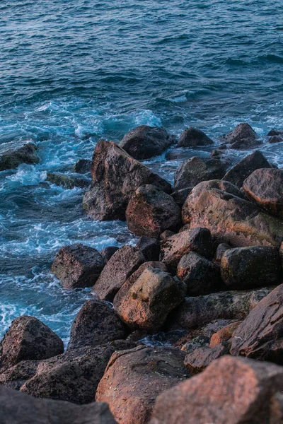 石头海滩日落与波浪和泡沫 — 图库照片