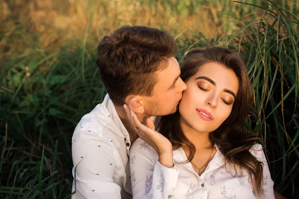 Casal Jovem Sentado Grama Jovem Beija Uma Mulher Feliz Jovem — Fotografia de Stock