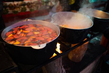 Sıcak gluhwein ya da yerel bir ikramda sıcak ve baharatlı bir kazanda sıcak şarap. Geleneksel bir narenciye içkisi. Kış festivalinde vitaminler. Noel pazarı.