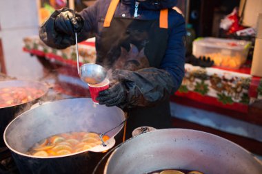 Sıcak gluhwein ya da yerel bir ikramda sıcak ve baharatlı bir kazanda sıcak şarap. Geleneksel bir narenciye içkisi. Kış festivalinde vitaminler. Noel pazarı.