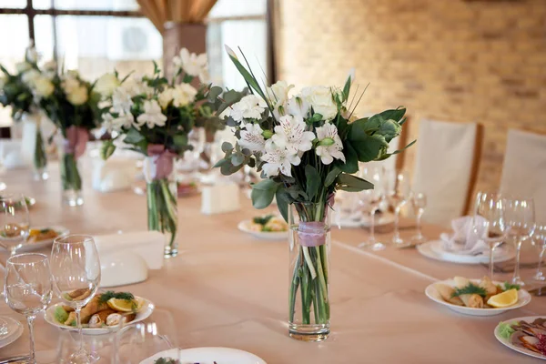 Wedding table decorated with flowers. Table setting for a banquet before the meal. Beautiful table setting on a holiday.