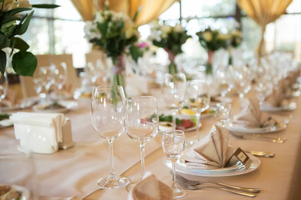 Wedding table decorated with flowers. Table setting for a banquet before the meal. Beautiful table setting on a holiday.