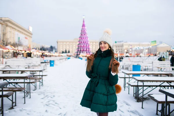 Beautiful woman in the winter on the street with New Year decora