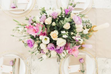 Çiçekli düğün süsü. Taze çiçeklerle süslenmiş düğün masası. Düğün çiçekçisi olarak. Güllü buket, Eustoma ve okaliptüs yapraklı..