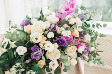 Çiçekli düğün süsü. Taze çiçeklerle süslenmiş düğün masası. Düğün çiçekçisi olarak. Güllü buket, Eustoma ve okaliptüs yapraklı..