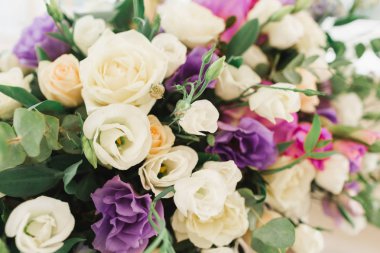 Çiçekli düğün süsü. Taze çiçeklerle süslenmiş düğün masası. Düğün çiçekçisi olarak. Güllü buket, Eustoma ve okaliptüs yapraklı..